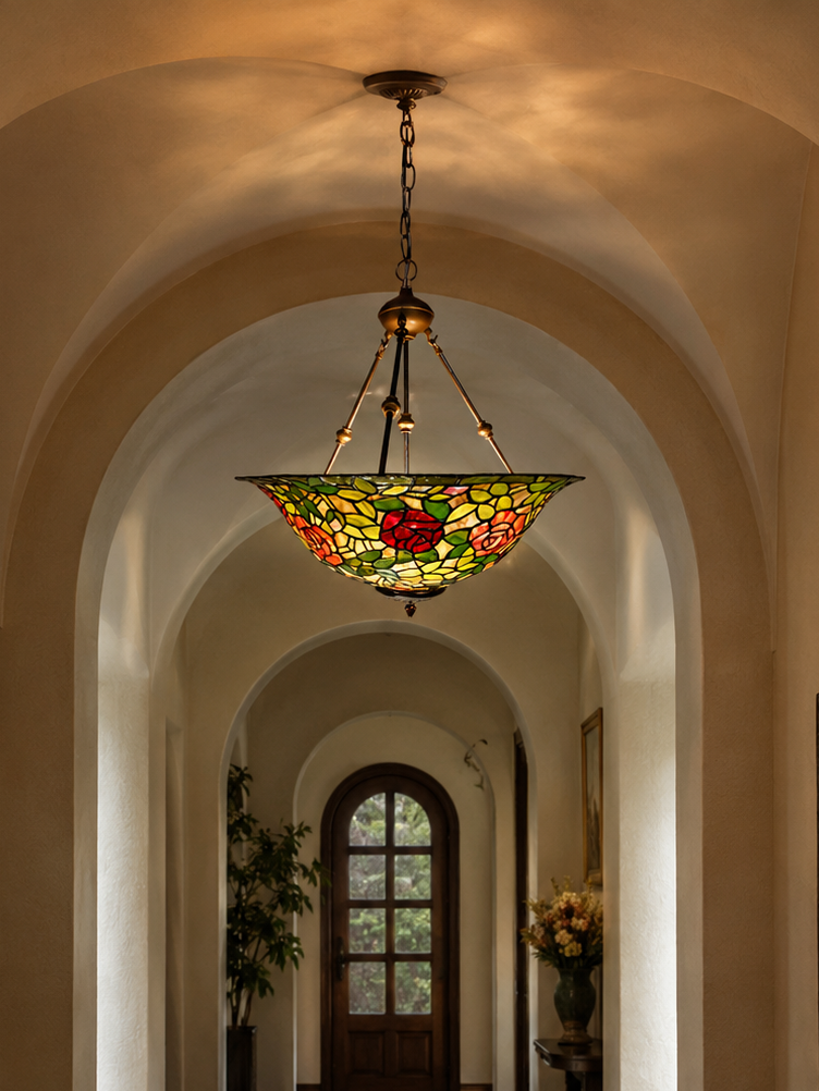 A stained glass chandelier with a red rose motif hangs in a long, arched hallway with a patterned runner rug and dark wood floors.